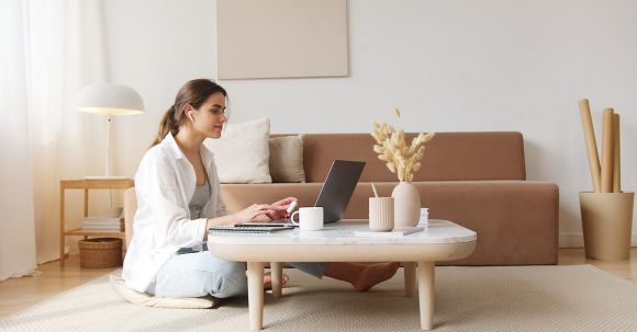 Smart Living - Content woman using laptop on floor